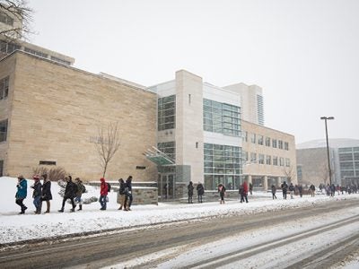 Photo of students walking outside Statler Hall in the snow