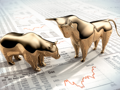 gold bulls figurines on stock market sheet