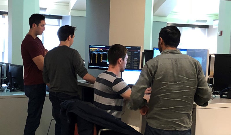 Photo of four students working in a computer lab