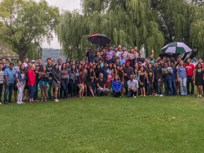 Photo of a large group of students in front of trees at the park