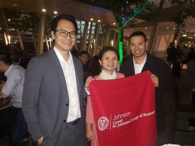 Photo of three people holding Johnson banner in a restaurant