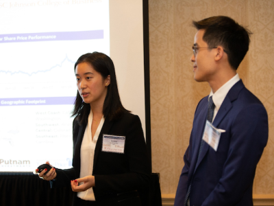 Eri and Sam stand in front of a presentation screen