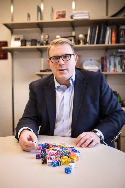 Photo of Vince Slaugh seating with a pile of dice on the table