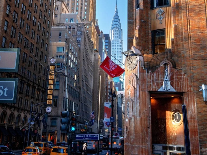 Cornell University flag on the General Electric building at 570 Lexington Ave with the Empire State Building visible in the background.