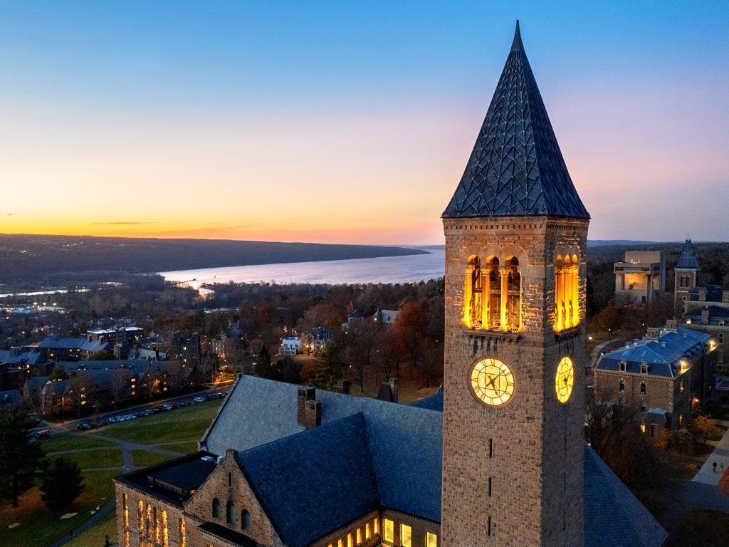 A photo of the Cornell clock tower, overlooking Cayuga lake, at dust.