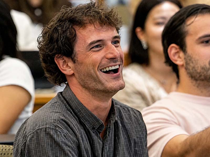 MBA student in audience smiling during MBA introduction day