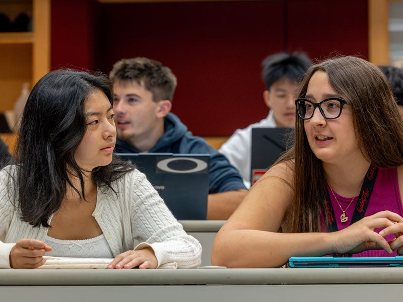 two students talking in classroom