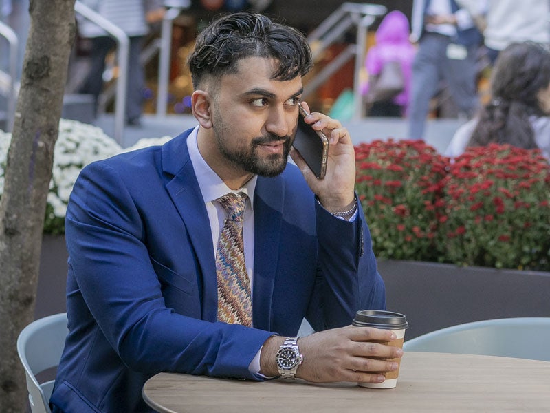 Man on phone at table in NYC