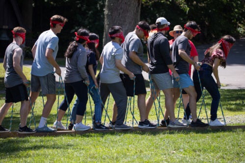 Cornell MBA students participate in an outdoor teamwork exercise entailing ropes and blindfolds as part of Johnson Outdoor Education (J.O.E.) events