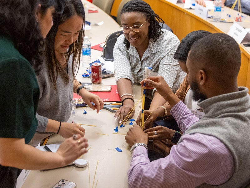 JGSM Diversity weekend students at table working on project.