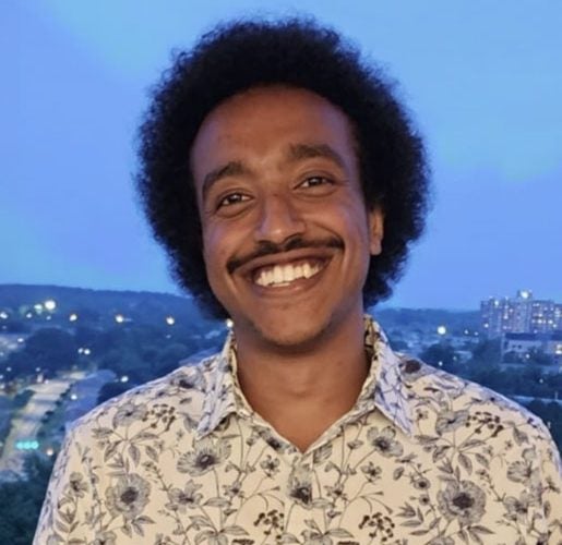 Headshot of Simon Taye.