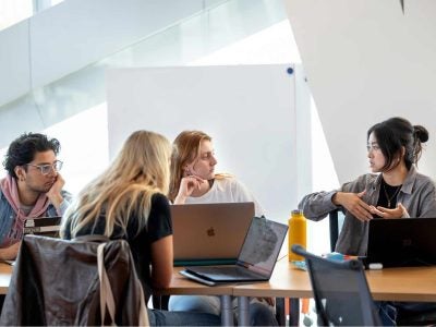 Four students work together around a table at Cornell Tech.