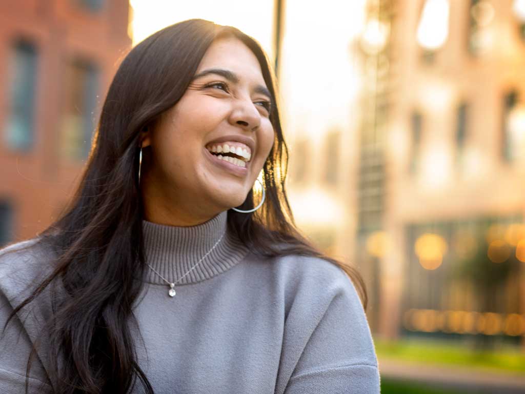 A women outside on campus smiling.