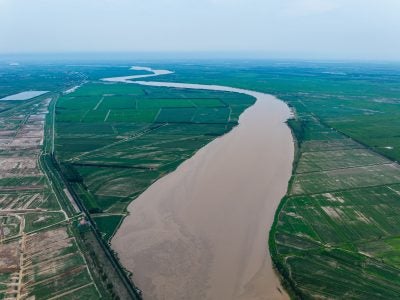 Aerial view of a river winding through farmland.