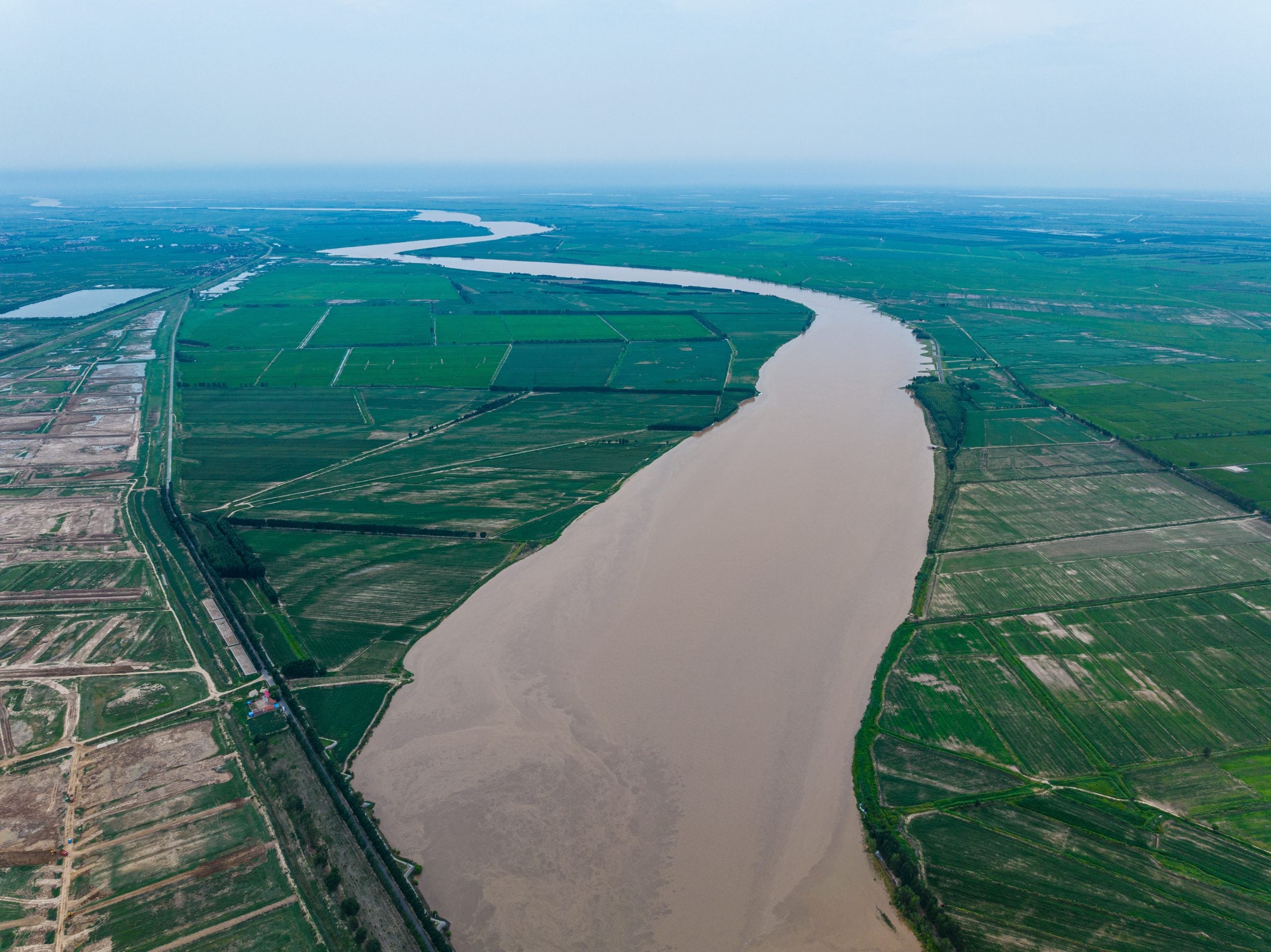 Aerial view of a river winding through farmland.