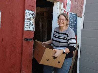 Melissa Keller carries a box into her barn.