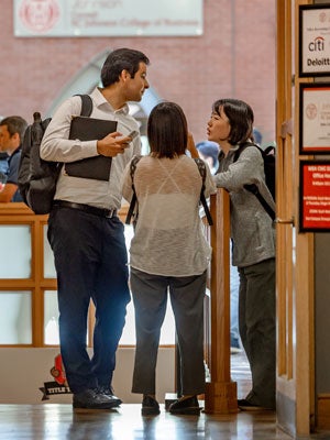 Two females and a male business student chatting in Sage Hall.