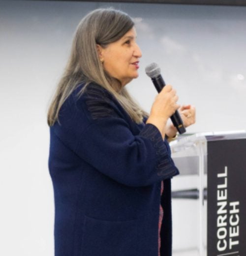 Lourdes Casanova speaking into a microphone at Cornell Tech.