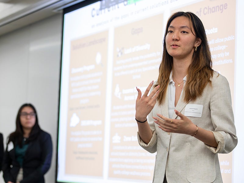 A Dyson student presenting in front of a projected screen as part of the Dyson Map the Challenge program.