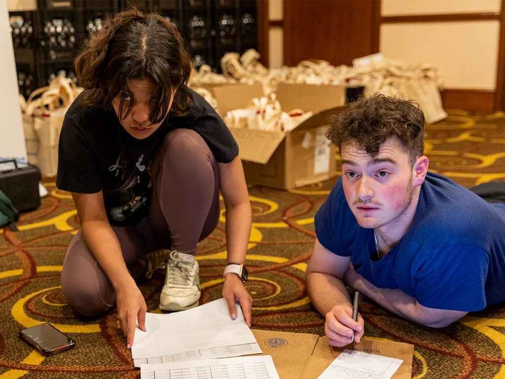 Two students sitting on the floor working together during prep work for HEC.