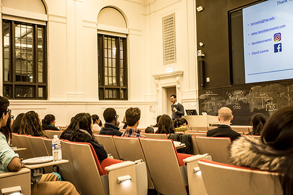 Image of Dr. David Levine talks to students in Warren Hall