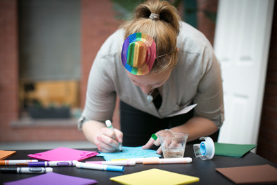 Photo of student writing a note at a Johnson Out for Business Event