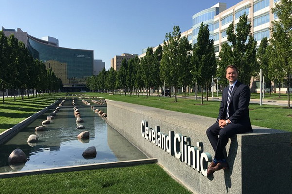 Andre sitting on a wall that says Cleveland Clinic
