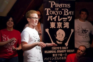 Photo of Jim next to a Pirates of Tokyo Bay banner