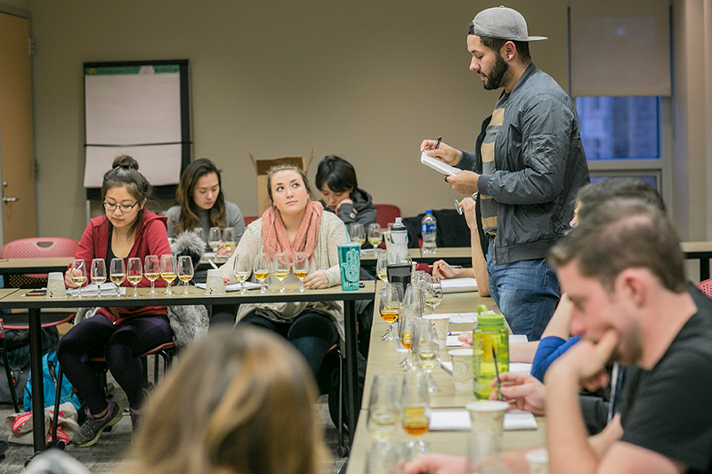 Photo of Andrew standing while others sit around the table