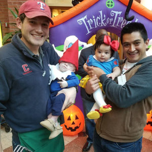 Photo of Carlos and Abby with another male student and child, dressed in Halloween costumes