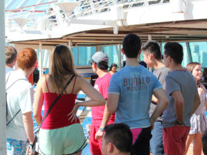 Photo of students gathered on the deck listen to a speaker