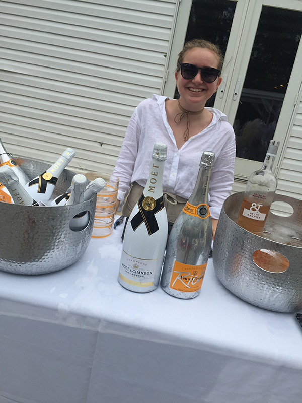 Photo of Marissa standing behind a table of beverages