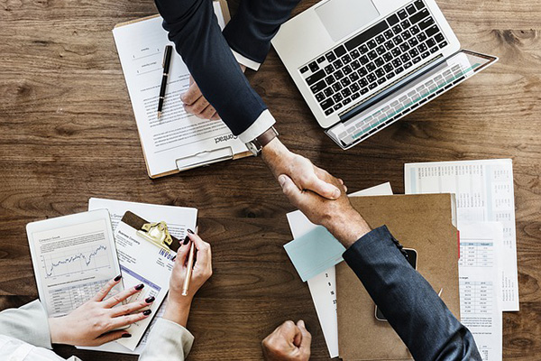 Photo of people shaking hands over a table