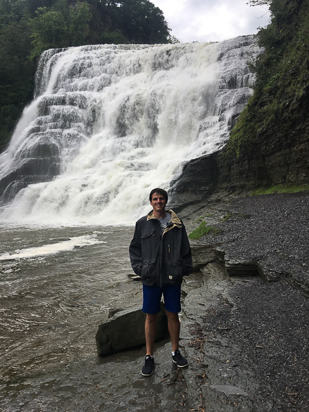 Photo of Matt standing in front of a waterfall