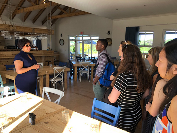 Photo of students listening to Vivian speak in front of the bar