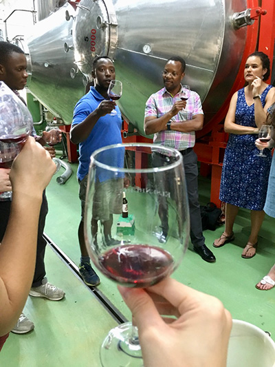 Photo of a wine glass and group of wine tasters