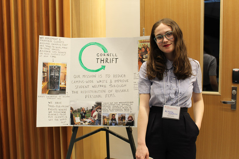 Photo of a student standing with her poster project