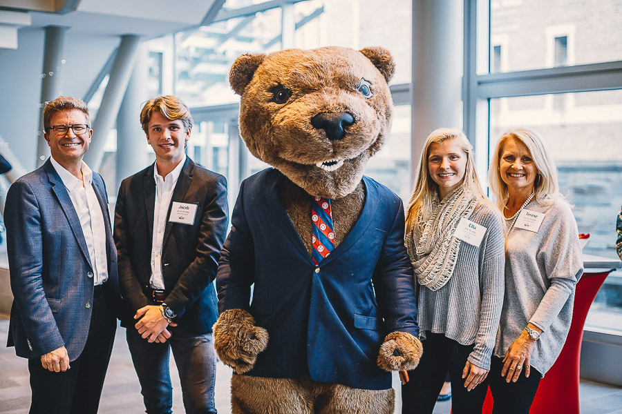 Photo of four people standing with Touchdown the mascot