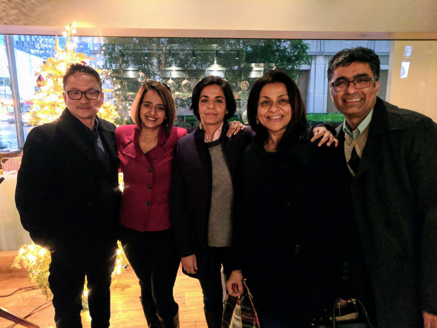 Photo of five people smiling and standing together