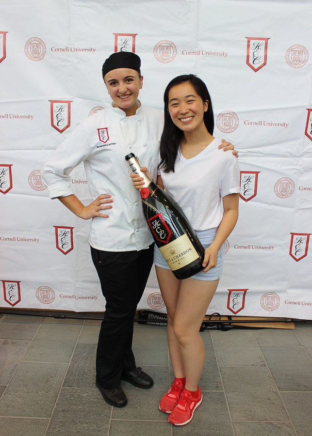 Photo of Eri and another student in from of a HEC banner