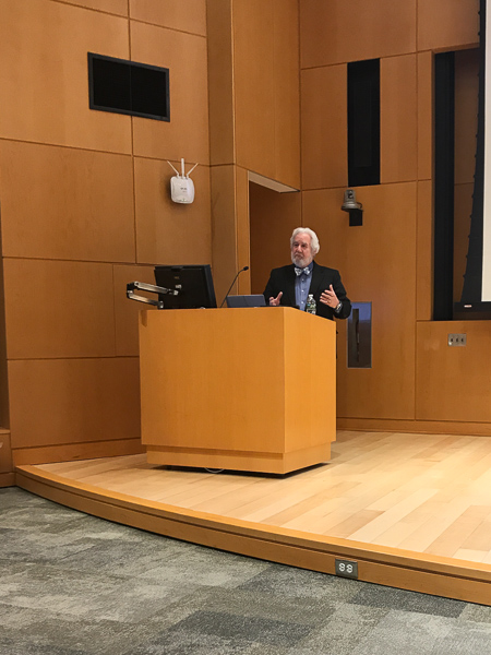 Photo of Karpman standing at a podium