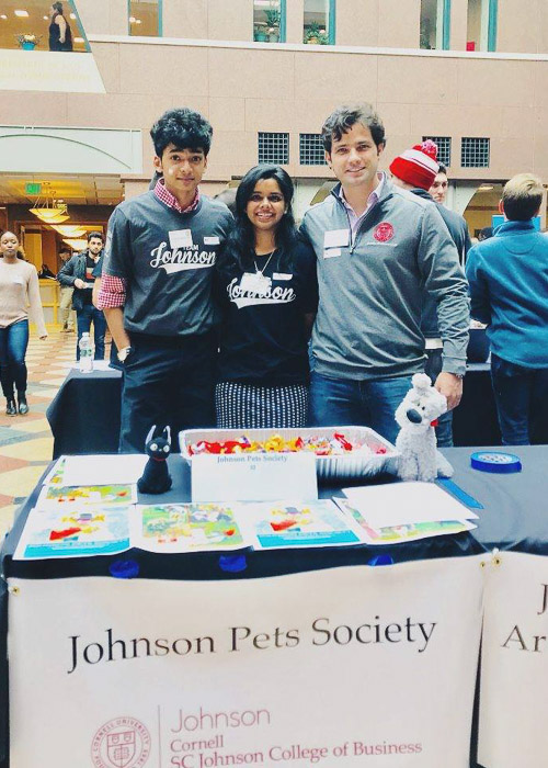 Students standing behind a table with a Johnson Pets Society banner