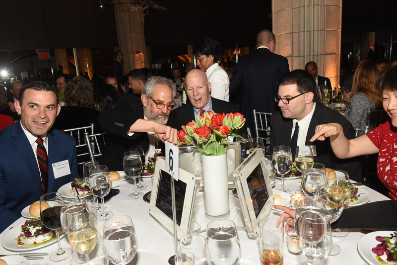 Photo of people sitting around a table interacting with iPads