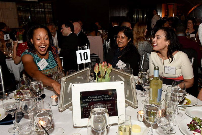 Photo of people sitting at a table interacting with iPads