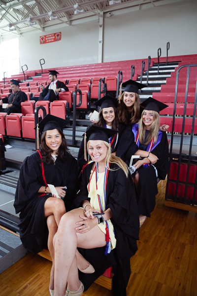 Photo of women graduates sitting on the bleachers