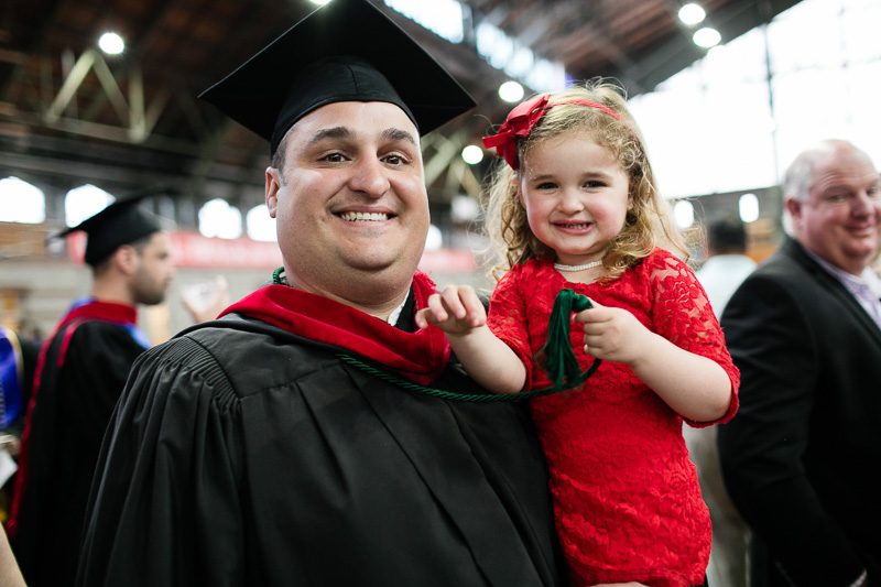 Photo of a graduate holding a young girl