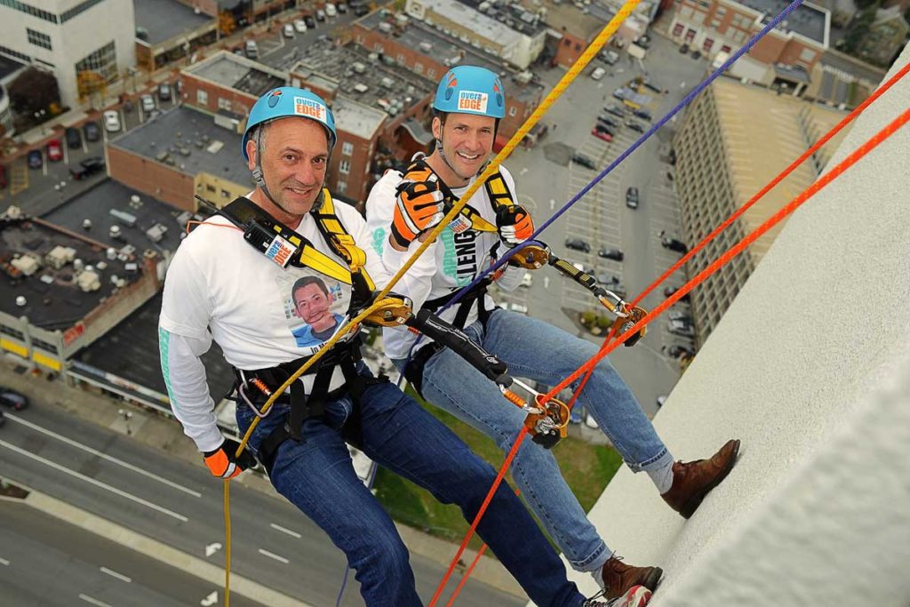 Photo of two men rappelling down the Landmark building