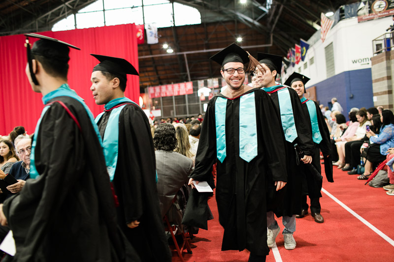 Photo of a line of graduates walking into the arena