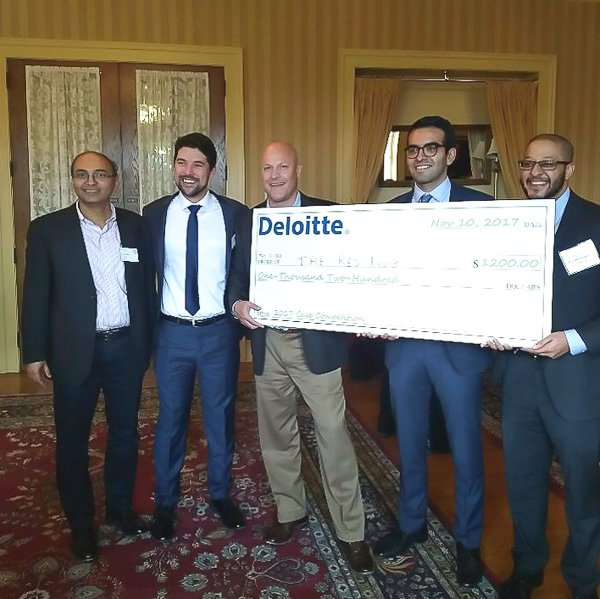 Photo of the team accepting their prize, holding a large check