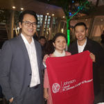 Photo of three people holding Johnson banner in a restaurant